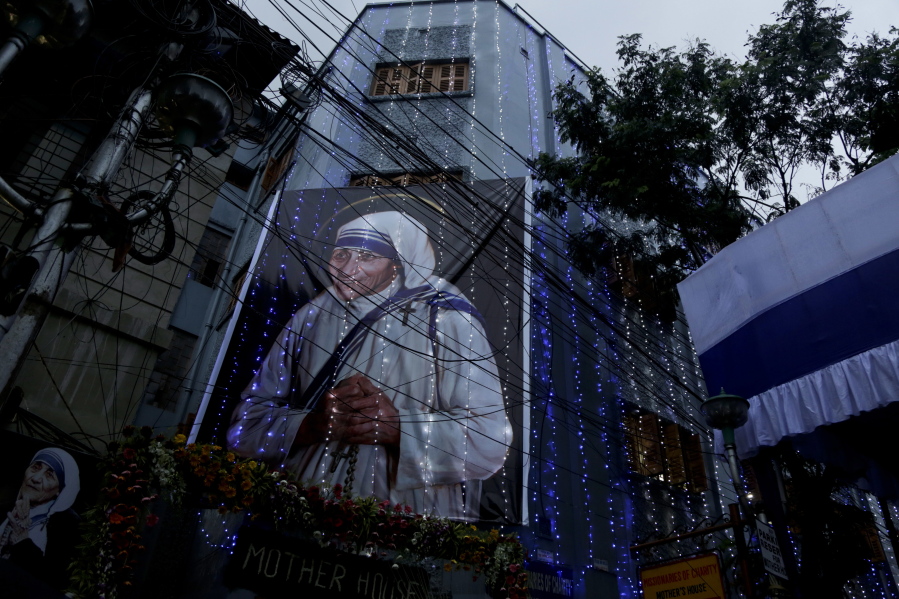Mother House of the Missionaries of Charity group founded by Mother Teresa is illuminated with a huge portrait of her displayed in Kolkata, India, Sunday, Sept. 4, 2016.