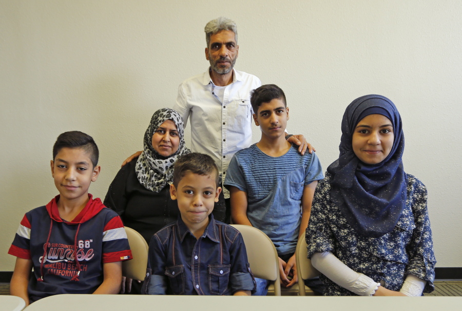 Nadim Fawzi Jouriyeh, rear, a Syrian refugee that arrived with his family in the United States this week, poses with the family Wednesday in El Cajon, Calif. The family members are his wife Rajaa Abdo Altaleb, back left, son Mohammad Fawzi Jouriyeh, back right, daughter Hanan Nadim Jouriyeh, right, Farouq Nadim Jouriyeh, front center, and Hamzeh Nadim Jouriyeh, front left.