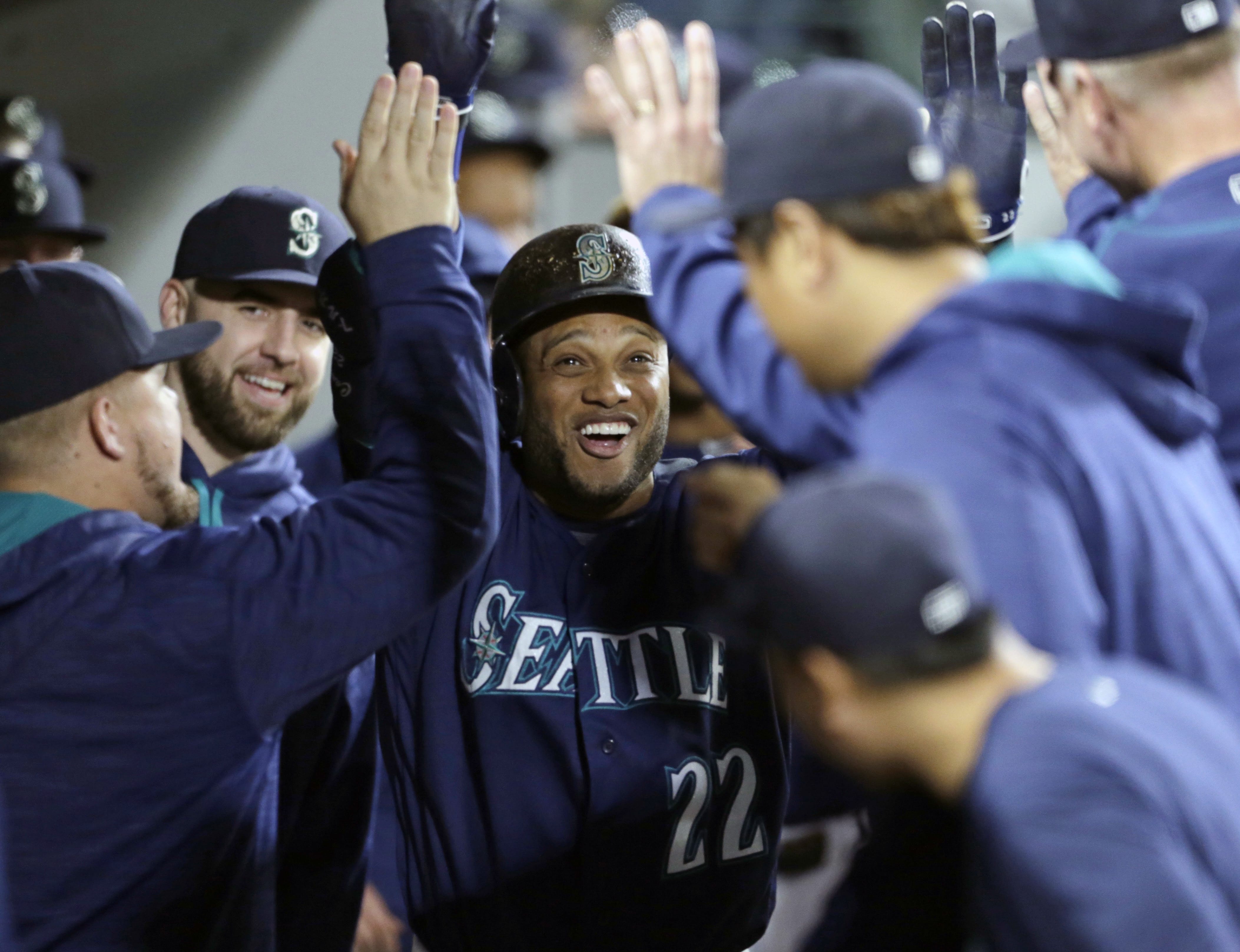 Seattle Mariners' Robinson Cano is congratulated in the dugout after hitting a solo home run on a pitch from Oakland Athletics starter Raul Alcantara during the third inning of a baseball game on Friday, Sept. 30, 2016, in Seattle.