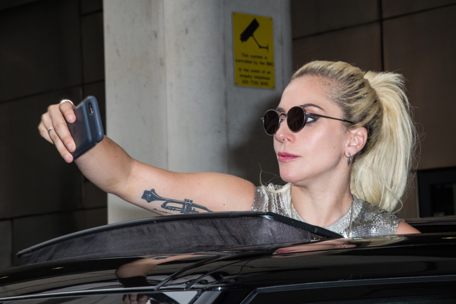 Lady Gaga takes photographs as she leaves the BBC Broadcasting House after co-hosting the BBC Radio 1&#039;s breakfast show Sept. 9 in London.