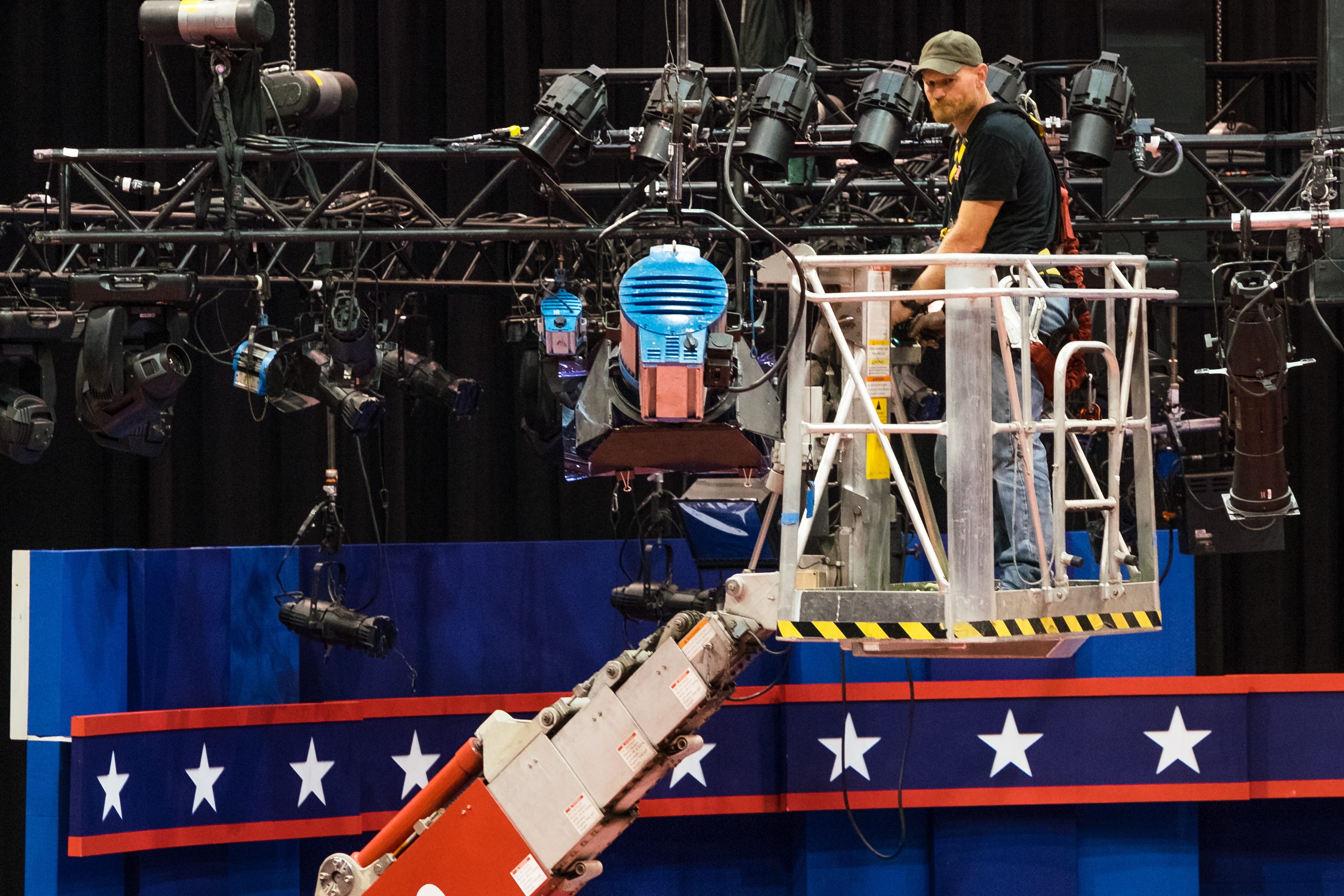 A technician examines the lighting grid as preparations continue for Monday's first debate presidential between Democratic Hillary Clinton and Republican Donald Trump, Saturday, Sept. 24, 2016, at Hofstra University in Hempstead, N.Y.  (AP Photo/J.