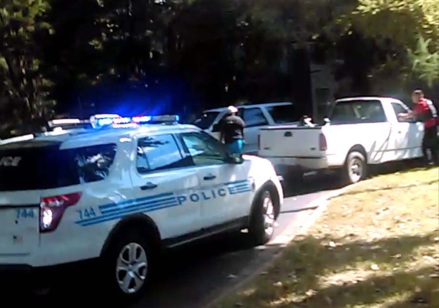 In this image from video recorded by Rakeyia Scott on Tuesday, her husband, Keith Lamont Scott, center, stands amid police cars and other vehicles moments before he is shot by a police officer in Charlotte, N.C. The video does not show clearly whether Scott had a gun.