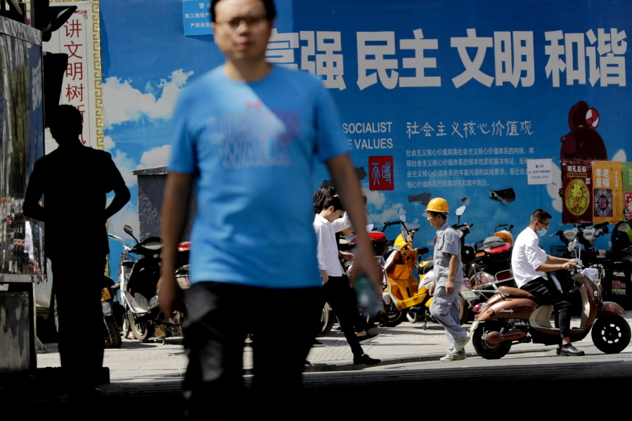 People walk by scooters parked against a billboard displaying a Chinese government propaganda message in Beijing, Friday. Leaders of the U.S., China and other big Group of 20 economies will be attending a two-day meeting this weekend, with the global economy expected to be one of the main discussion topics. China, the G-20 meeting&#039;s host, has made trade a major theme of the meeting while other governments also want to tackle climate change, cutting excess capacity in steel and limits on use of tax havens.