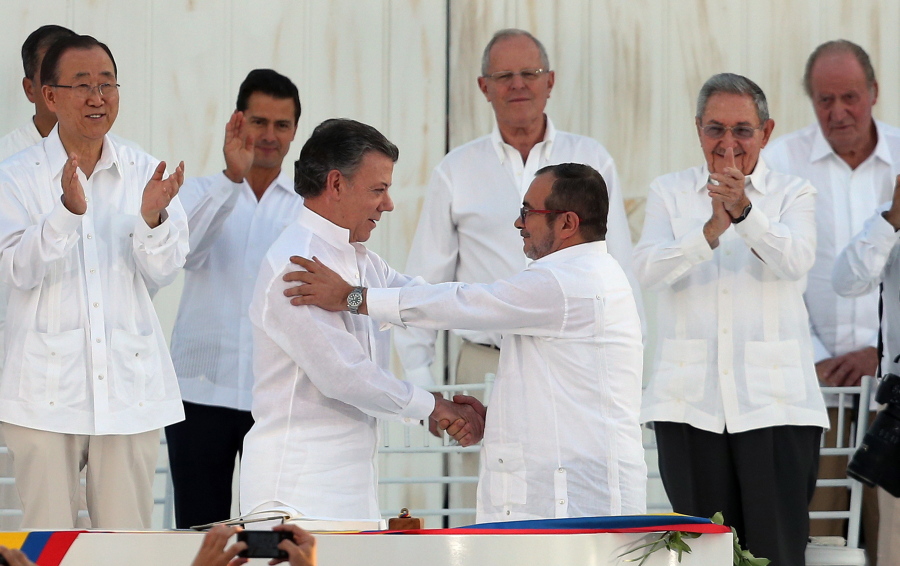 ColombiaC?Us President Juan Manuel Santos, front left, and the top commander of the Revolutionary Armed Forces of Colombia (FARC) Rodrigo Londono, known by the alias Timochenko, shake hands after signing the peace agreement between ColombiaC?Us government and the FARC to end over 50 years of conflict in Cartagena, Colombia, Monday, Sept. 26, 2016. Behind, from left, are U.N. Secretary General Ban Ki Moon, Mexico&#039;s President Enrique Pena Nieto, Peru&#039;s President Pedro Pablo Kuczynski, Cuba&#039;s President Raul Castro, and Spain&#039;s former King Juan Carlos.