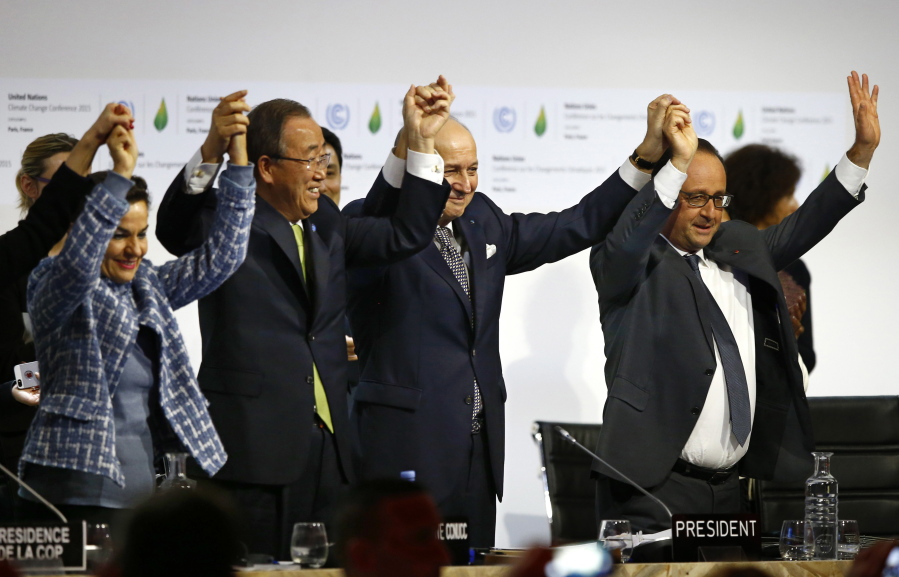 United Nations climate chief Christiana Figueres, from left, United Nations Secretary-General Ban Ki-moon, French Foreign Minister and president of the COP21 Laurent Fabius, and French President Francois Hollande hold their hands up in celebration Dec. 12, 2015, after the final conference at the COP21, the United Nations conference on climate change, in Le Bourget,France.