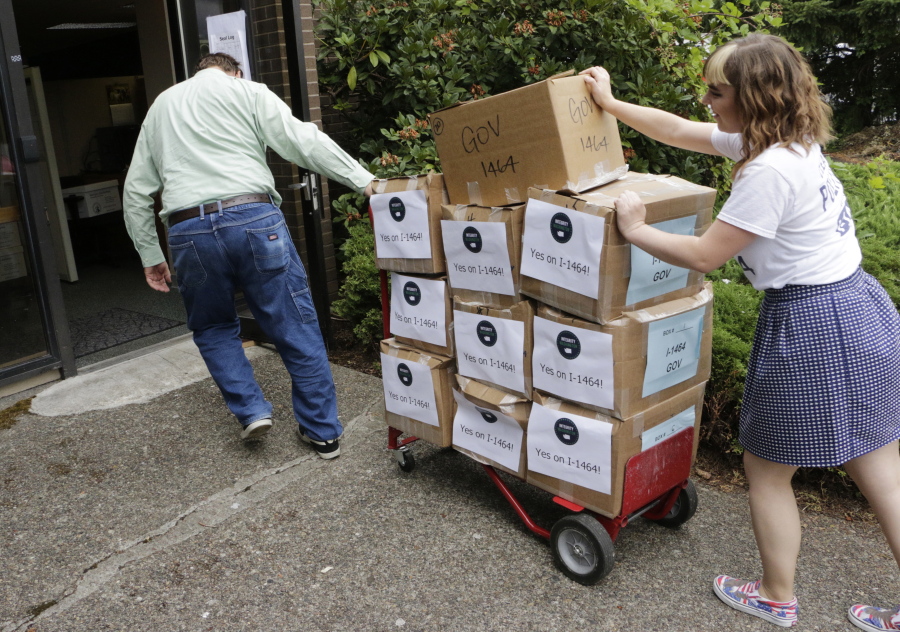 Supporters of a proposed campaign finance reform ballot measure arrive July 8 to turn in boxes of signed petitions in Olympia. Washington voters will soon decide whether or not to make the most sweeping changes to the state&#039;s campaign finance system in decades.