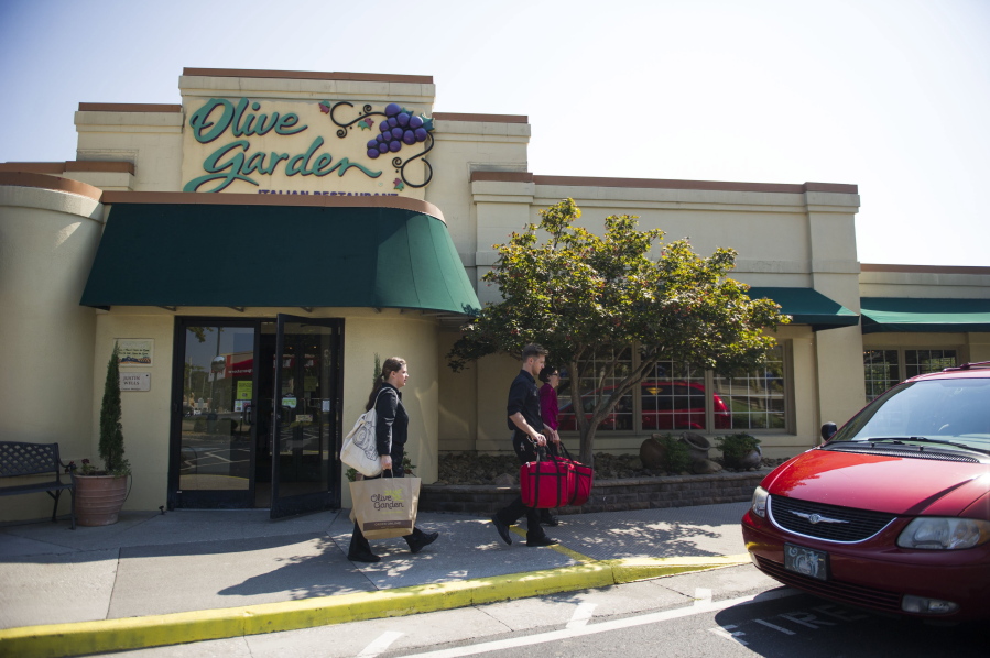 Employees carry delivery food out of an Olive Garden in Knoxville, Tenn.