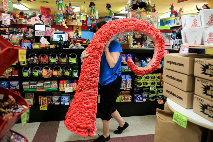 Jackie Sugita carries a tentacle display to the garbage at Archie McPhees in the Wallingford neighborhood of Seattle. Yodeling pickles, bonnets for cats, Bigfoot action figures and the other wacky creations are sold at the store.