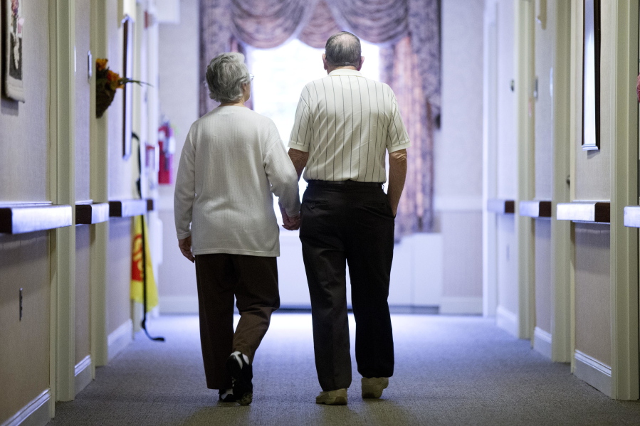 An elderly couple walks down a hall Nov. 6 in Easton, Pa. Analysis of a study released Monday suggests exercise may be as important as medication for high-risk seniors.