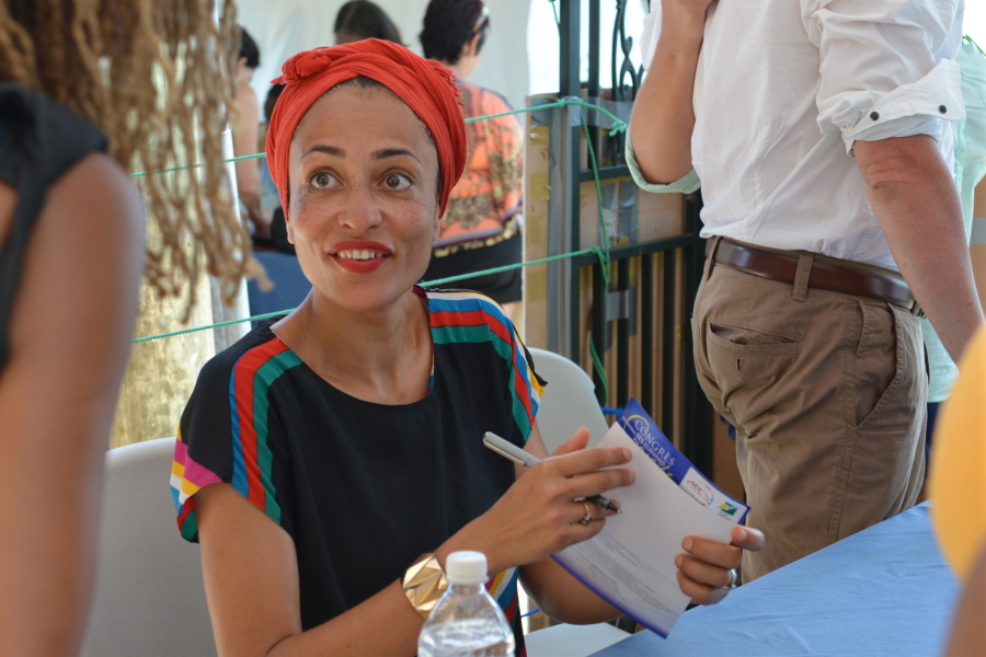 In a May 31, 2014 file photo, acclaimed novelist Zadie Smith is shown signing a book for a fan in Treasure Beach, Jamaica. Fall is the time for &quot;big books,&quot; whatever the page length, and some of the top fiction authors from around the world have new works coming in 2016, including Ian McEwan, Zadie Smith, Margaret Atwood, T. Coraghessan Boyle, Rabih Alameddine, Emma Donoghue, Jonathan Safran Foer and Michael Chabon.