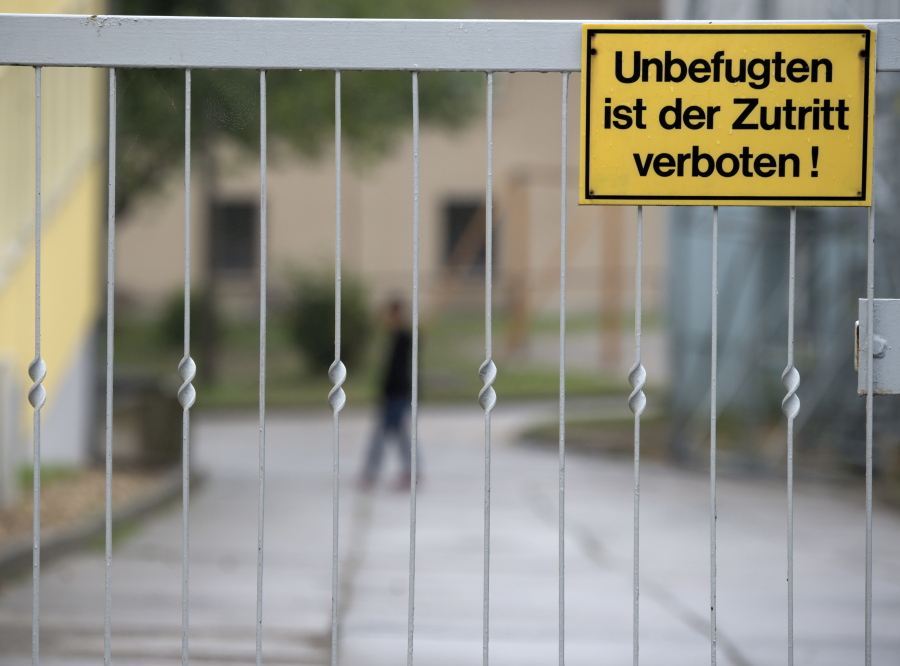 A person walks behind a refugee home entrance in Bautzen, eastern Germany. The words read: &#039;No admission for unauthorized persons&#039;. Verbal and violent attacks have erupted between about 80 Germans and around 20 young asylum seekers in Bautzen, a town between Dresden and the Polish border, last Wednesday.