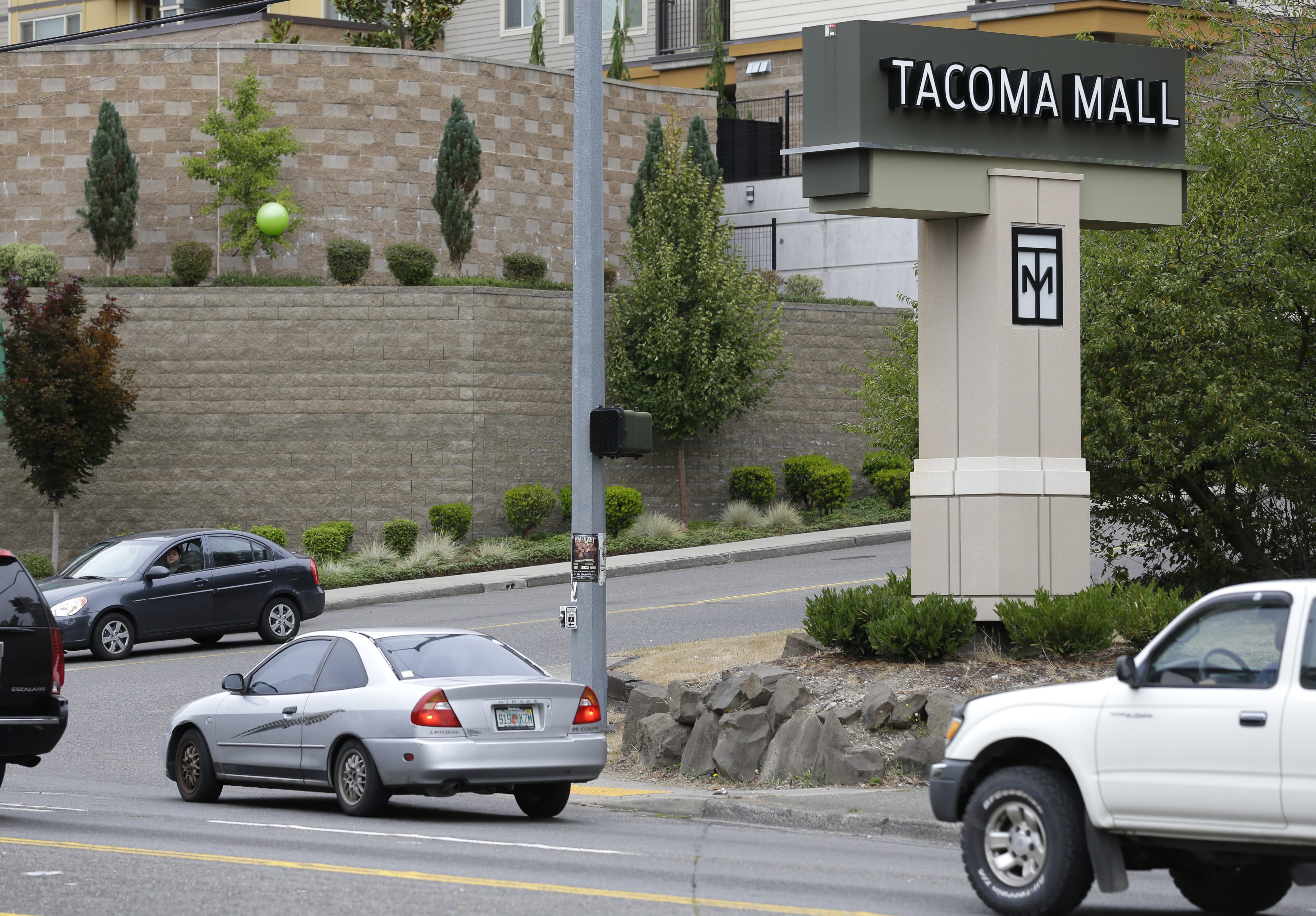Cars pass by an entrance to the Tacoma Mall, Wednesday, Sept. 7, 2016, in Tacoma, Wash. A Washington state teenager who was riding her bicycle through the mall parking lot when an off-duty officer working as a security guard threw her to the ground and shocked her with a stun gun is suing the Tacoma Police Department. (AP Photo/Ted S.