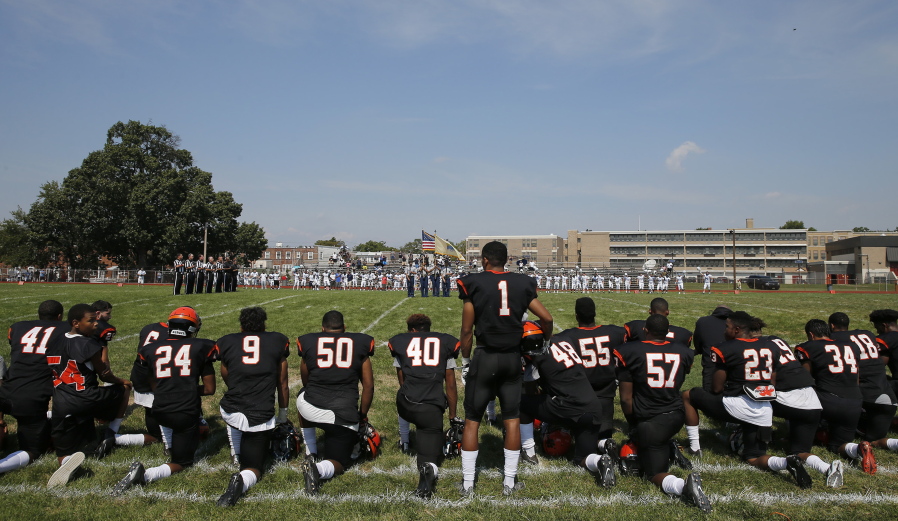 Woodrow Wilson High&#039;s Edwin Lopez (1) stands while some of his teammates kneel during the national anthem before Wilson played Highland Camden, N.J., on Saturday.