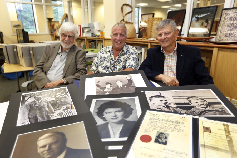 Keene State College professors, from left, Lawrence Benaquist, Tom Durnford, and Paul Vincent show the photos that they used to research a Massachusetts couple who helped Jewish refugees flee the Nazis during World War II.