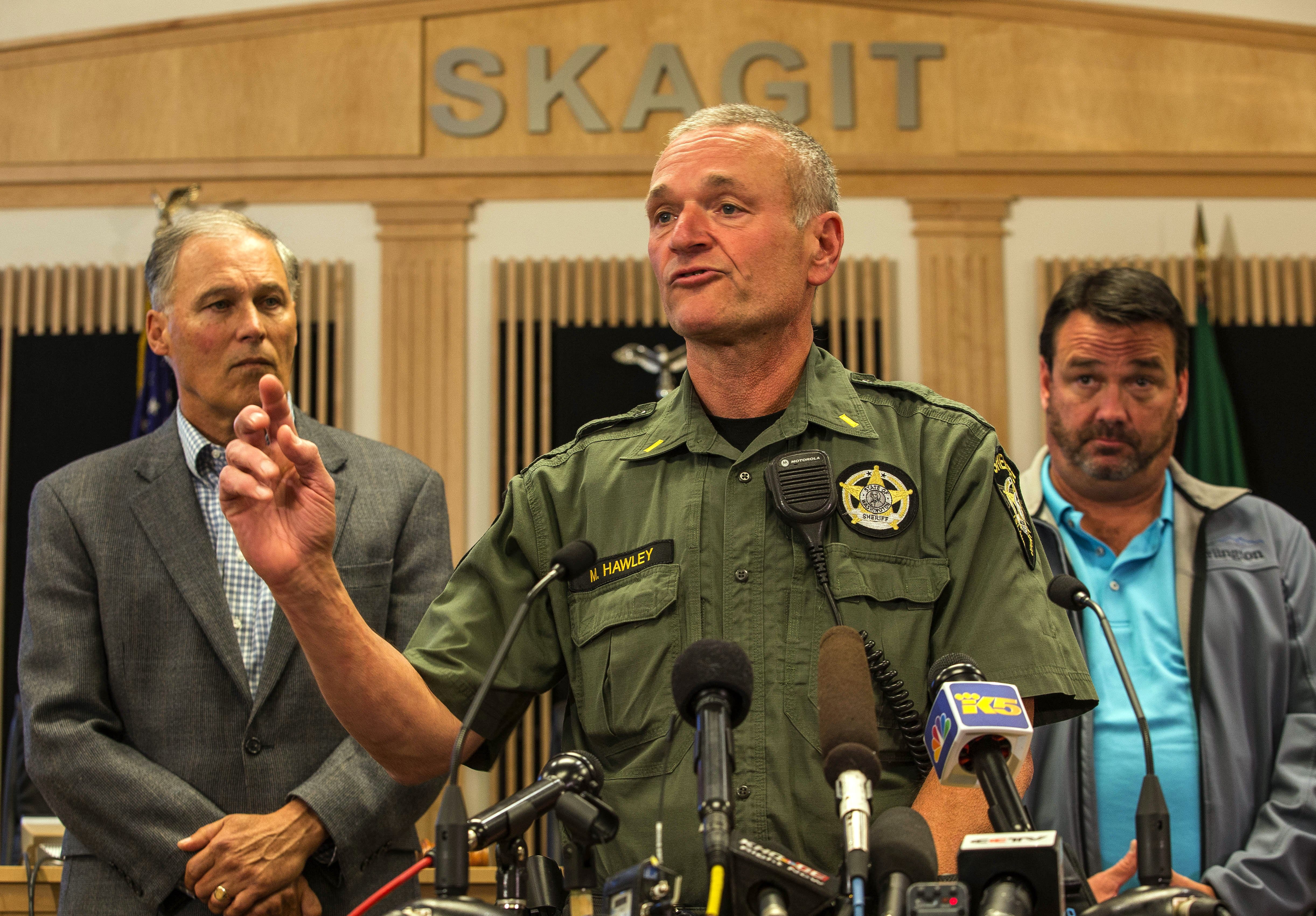Lt. Mike Hawley with Island County Sheriff's office discusses the capture of Arcan Cetin, 20, who was wanted in connection with Friday's mass shooting at Cascade Mall in Burlington on Friday.  Officials, including Washington Gov. Jay Inslee, left, gathered Saturday in the Skagit County chambers in Mt. Vernon.