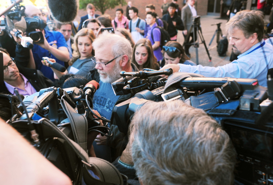 Arcan Cetin&#039;s stepfather David Marshall is swarmed by the media outside the Skagit County District Court on Monday moments after Cetin appeared in court under a magistrate&#039;s warrant which will give Skagit County prosecutors 30 days to file official charges against him in the Cascade Mall shooting where five people were murdered on Friday, Sept. 22, in Burlington.