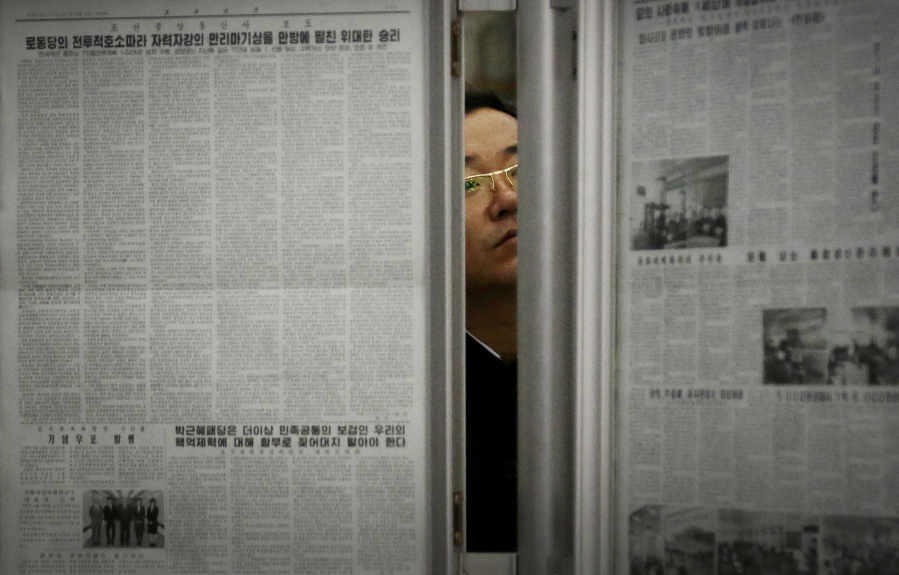 A North Korean man reads the local newspapers displayed in a subway station as seen during a press tour in Pyongyang, North Korea.