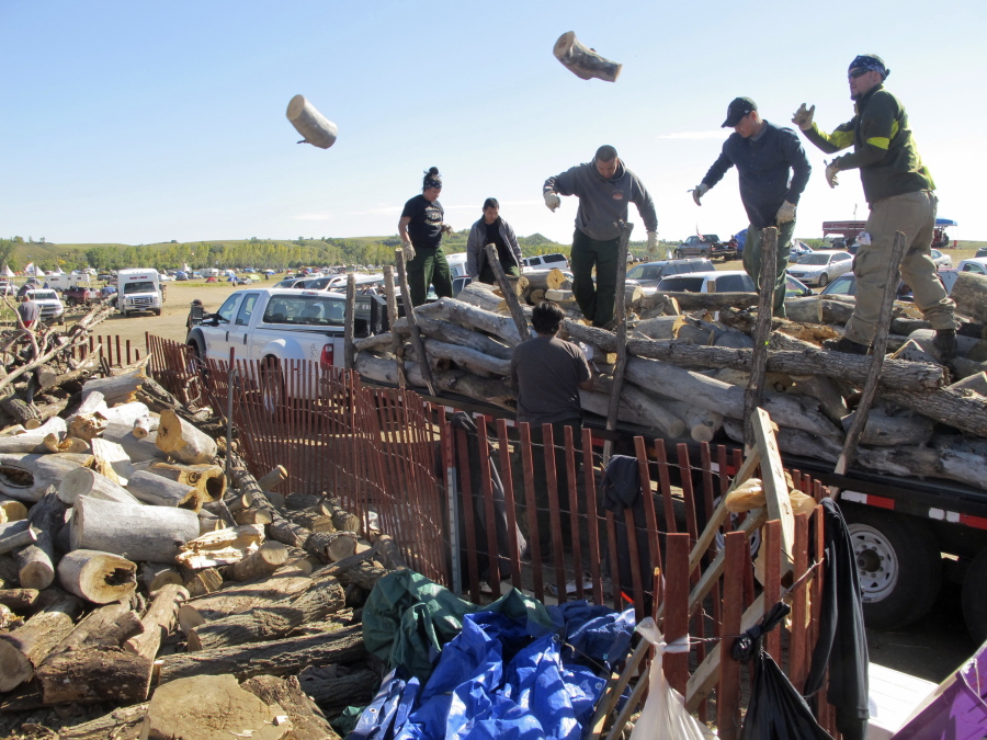 Volunteers Wednesday toss logs at an oil pipeline protest encampment near the Standing Rock Sioux Reservation in southern North Dakota. The logs will be used to cook meals for the thousands of people who have come to the area to fight the $3.8 billion Dakota Access pipeline.