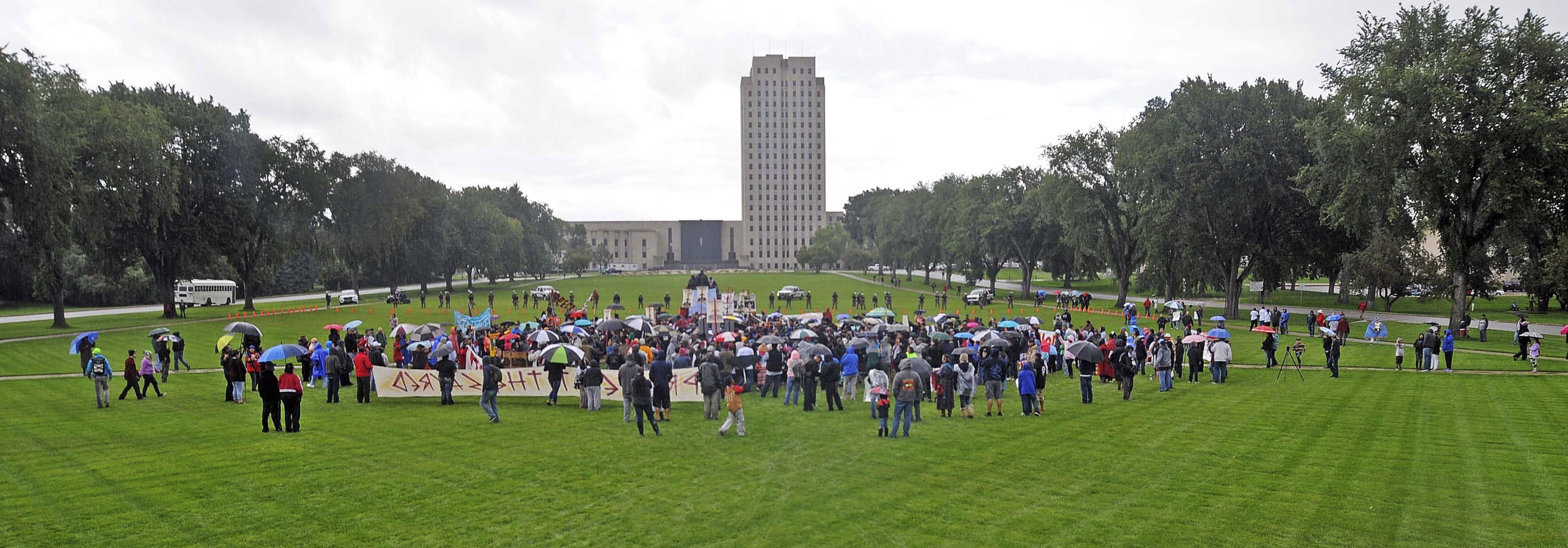 People rally against the Dakota Access Pipeline  on the grounds of the North Dakota state capitol Friday, Sept. 9, 2016 in Bismarck, N.D. The federal government stepped into the fight over the Dakota Access oil pipeline Friday, ordering work to stop on one segment of the project in North Dakota and asking the Texas-based company building it to "voluntarily pause" action on a wider span that an American Indian tribe says holds sacred artifacts.