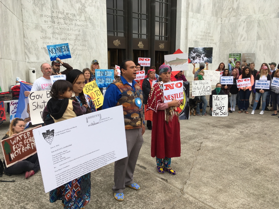 Native American protestors and others on Wednesday gather in front of the Oregon State Capitol in Salem, Ore. The group is protesting plans by Nestle to build a water bottling plant in the town of Cascade Locks, Ore.