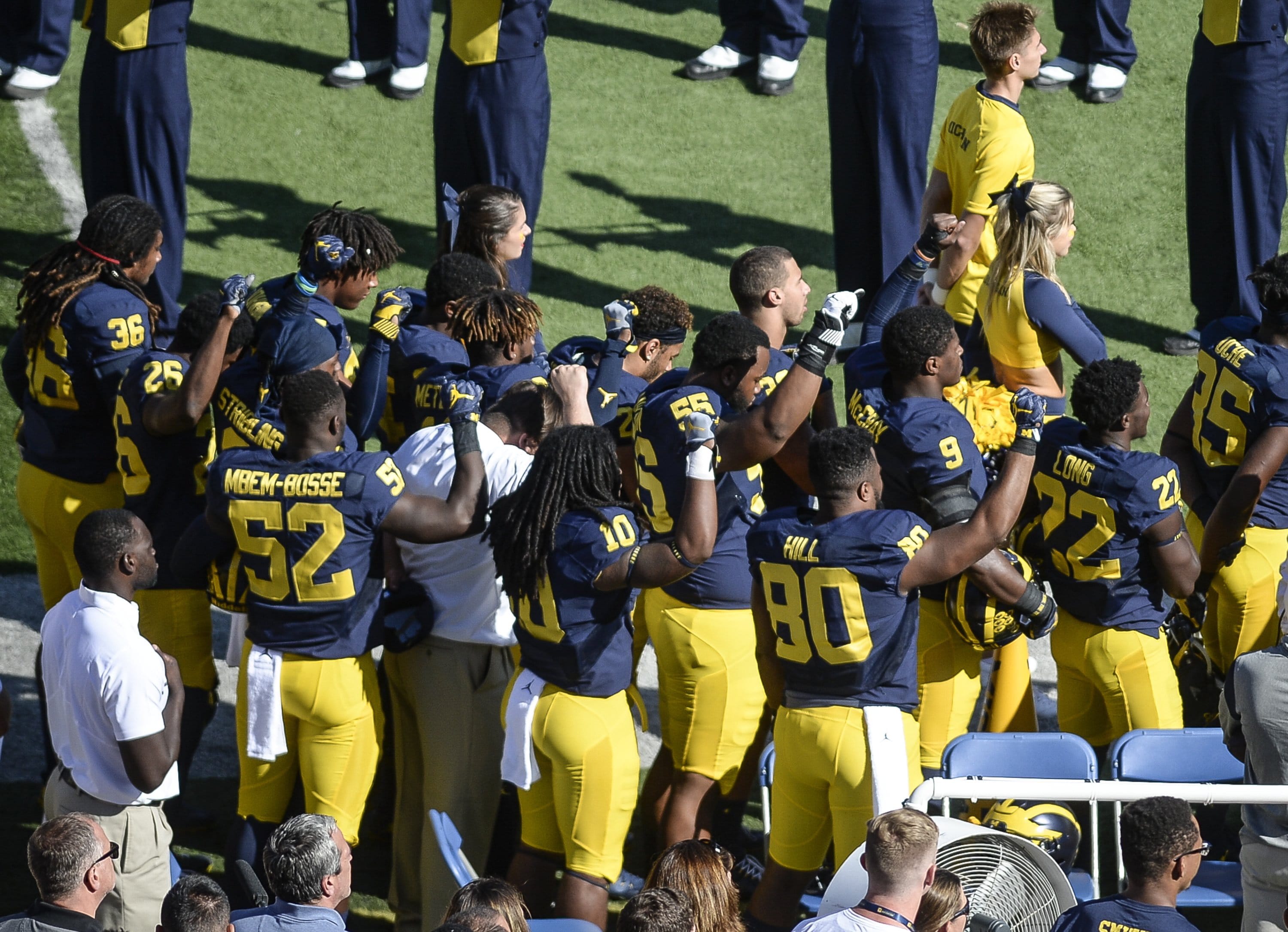 Michigan football players raise their fists up in protest during the National Anthem, before an NCAA college football game against Penn State, Saturday, Sept. 24, 2016, in Ann Arbor, Mich.