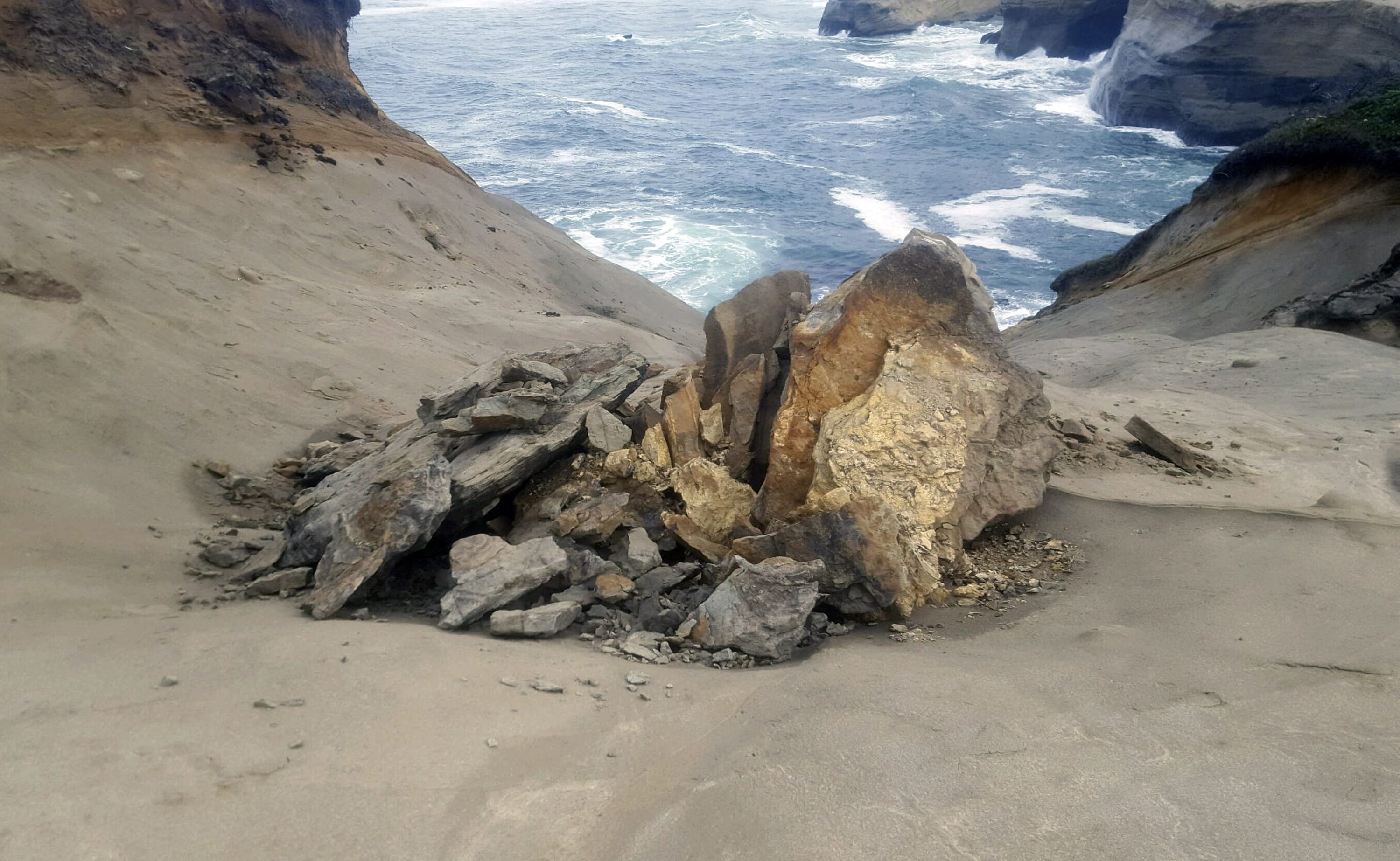 This undated photo provided by State of Oregon, Oregon Parks and Recreation Department shows a natural rock formation that was found in pieces last week at Cape Kiwanda State Natural Area  which is a state park in Pacific City, Ore. The sandstone pedestal was roughly 7 feet to 10 feet across and located in a fenced off section of the park. Oregon State Parks officials originally said they did not think the break at the site frequented by tourists was caused by humans but cellphone video captured a group of people knocking over the popular sandstone rock formation known as the "Duckbill" on the Oregon beach.