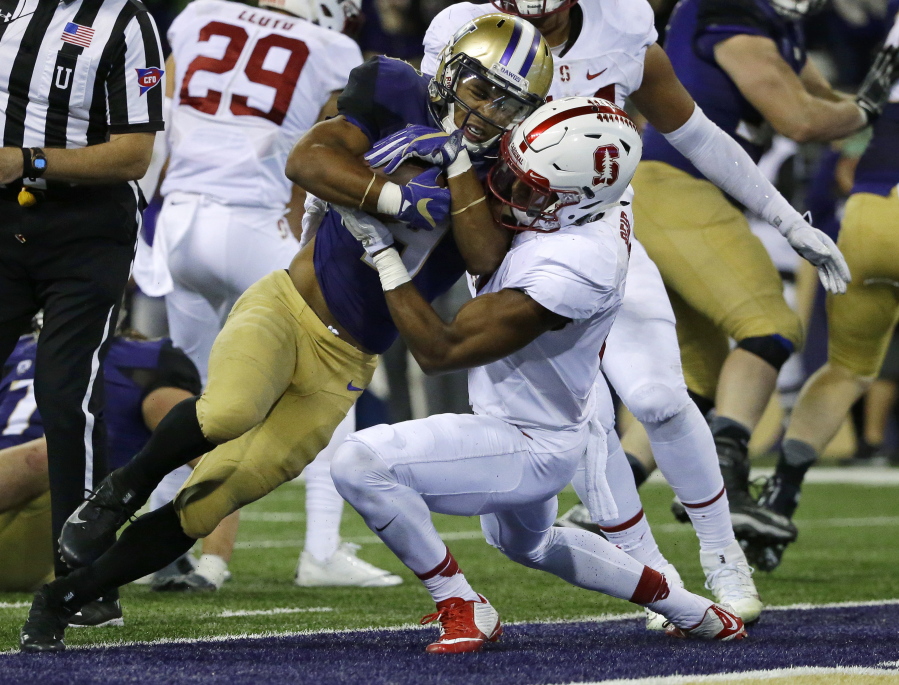 Washington running back Myles Gaskin, left, powers past Stanford safety Justin Reid, right, for a touchdown. Gaskin rushed for 100 yards in the win over Stanford. (Ted S.
