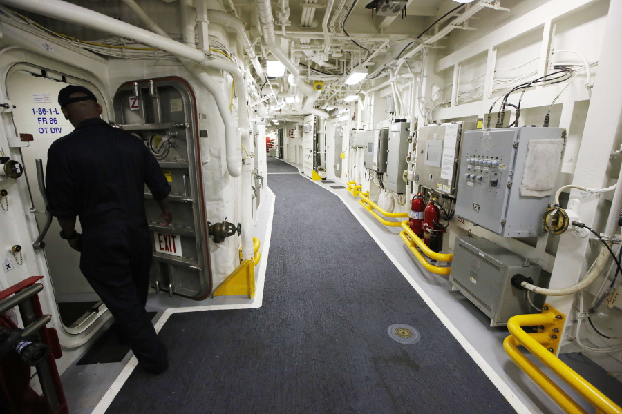 A sailor enters a doorway aboard the USS Zumwalt Friday while at the naval station in Newport, R.I.