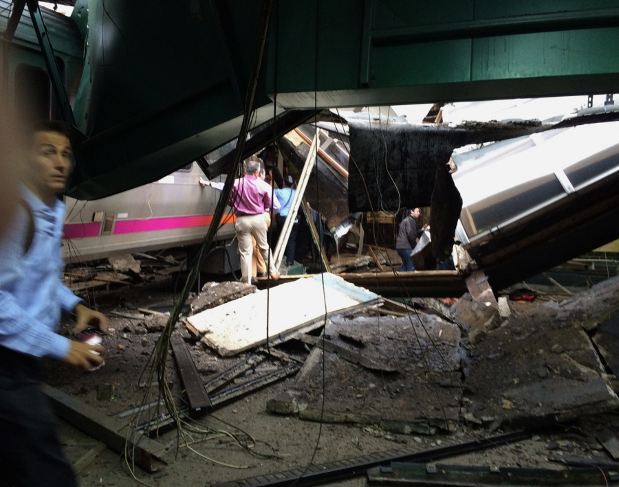 In a photo provided by William Sun, people examine the wreckage of a New Jersey Transit commuter train that crashed into the train station during the morning rush hour in Hoboken,, N.J., Thursday, Sept. 29, 2016. The crash caused an unknown number of injuries and witnesses reported seeing one woman trapped under concrete and many people bleeding.