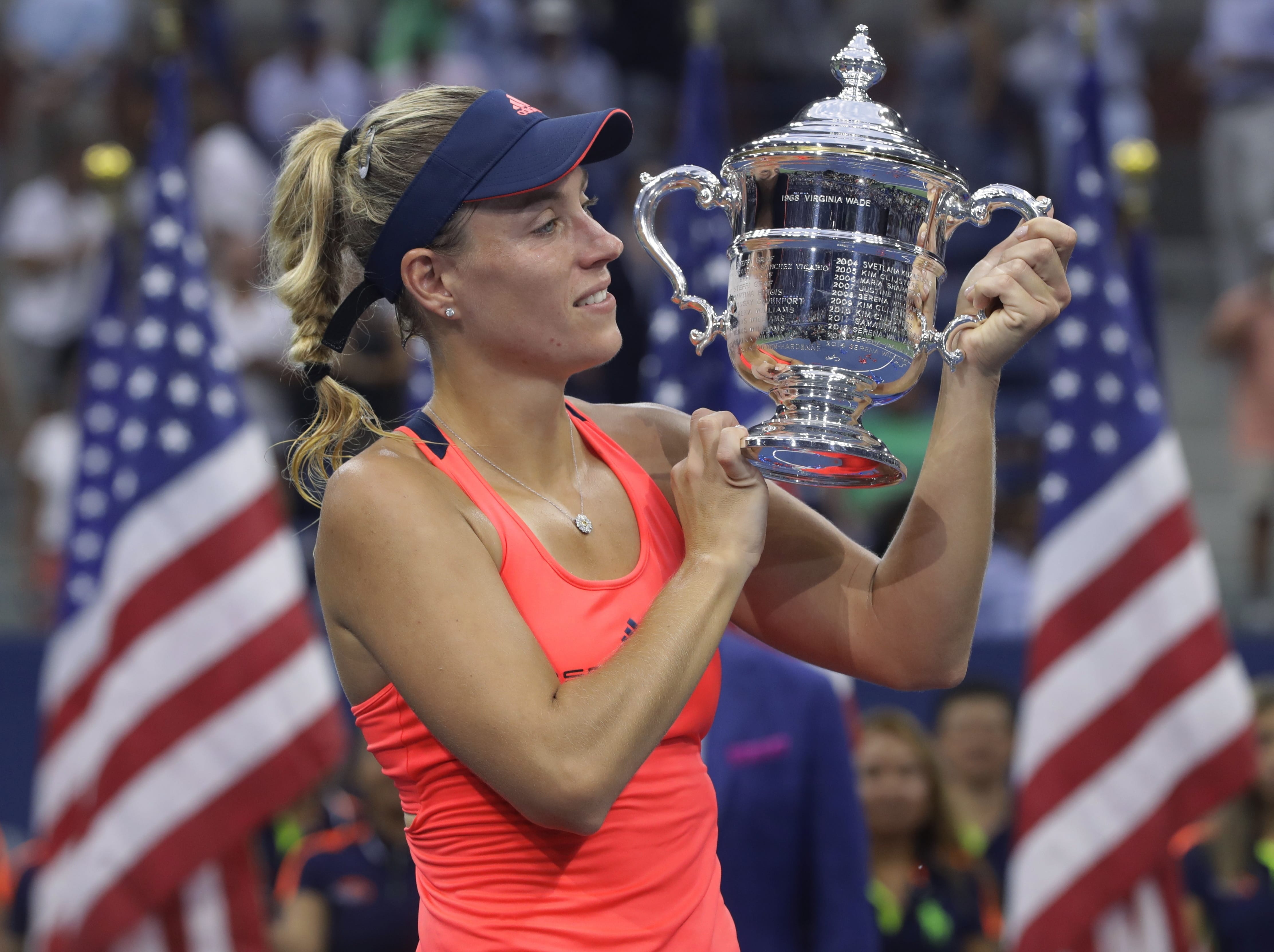 Angelique Kerber, of Germany, holds up the championship trophy after beating Karolina Pliskova, of the Czech Republic, to win the women's singles final of the U.S. Open tennis tournament, Saturday, Sept. 10, 2016, in New York.