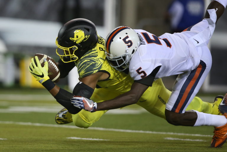 Oregon's Pharaoh Brown, left, is brought down by Virginia's Tim Harris after a pass receptions during the first quarter of an NCAA college football game Saturday, Sept. 10, 2016 in Eugene, Ore.