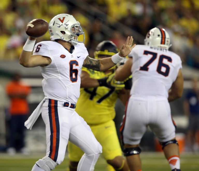 Virginia quarterback Kurt Benkert, left, drops back to pass against Oregon during the first quarter of an NCAA college football game Saturday, Sept. 10, 2016 in Eugene, Ore.