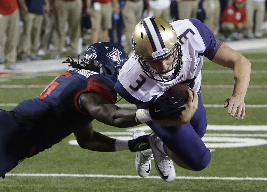 Washington quarterback Jake Browning (3) dives into the end zone with Arizona safety Demetrius Flannigan-Fowles hanging on during the second half of an NCAA college football game, Saturday, Sept. 24, 2016, in Tucson, Ariz. Washington defeated Arizona 35-28 in overtime.
