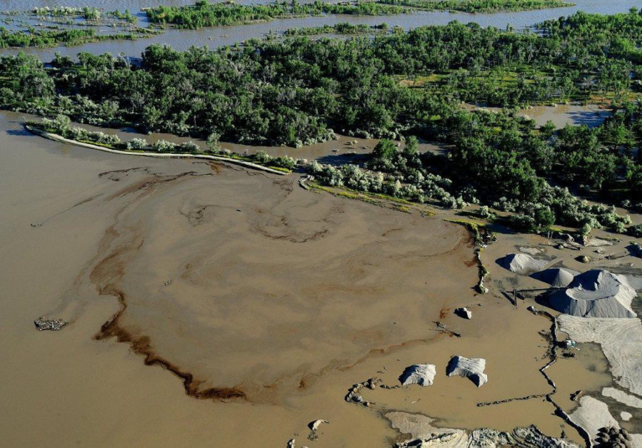 Oil swirls in a flooded gravel pit in Lockwood, Mont., after a pipeline break on July 2, 2011. Exxon Mobil Corporation has agreed to pay about $12 million for damages caused by the 2011 pipeline break that spilled gallons of crude into Montana&#039;s Yellowstone River, officials said Wednesday, Sept. 21, 2016.