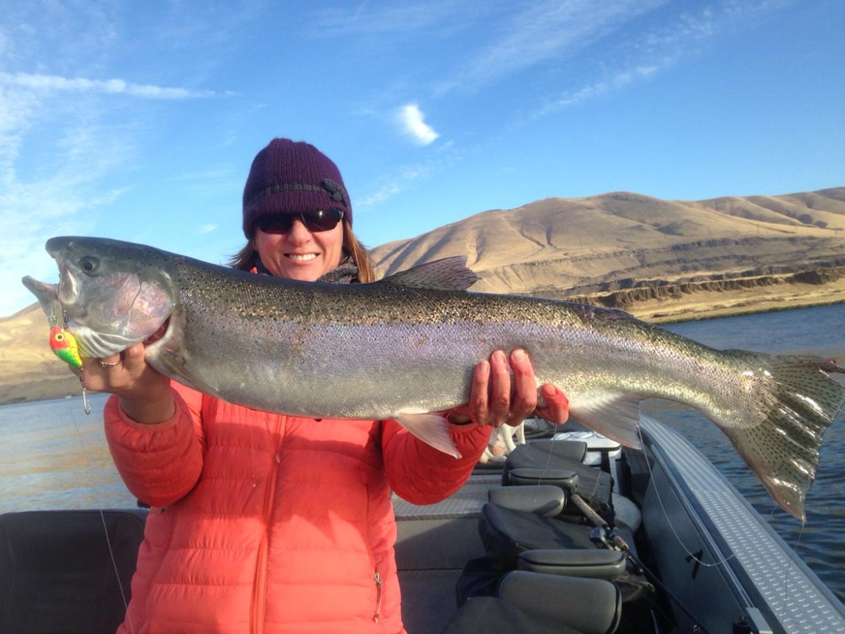 Machelle Dotson holds a steelhead landed in October in the Columbia River near the mouth of the Deschutes River.