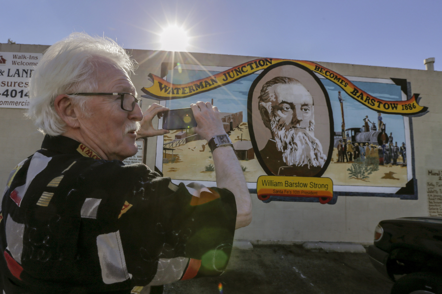 Canadian tourist Wayne Webb stops to take a photo of the mural &quot;Waterman Junction Becomes Barstow, 1886,&quot; on a building along Main Street in Barstow, Calif.