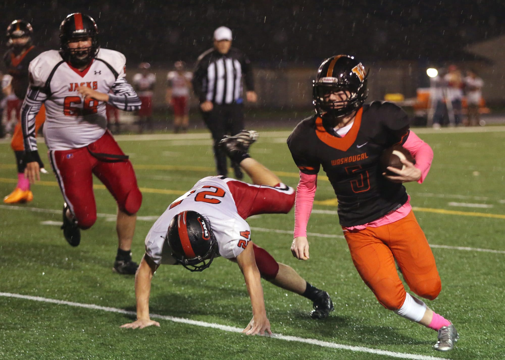 Washougal Panther Kade Coons runs with the ball as he is pursued by RA Long Lumberjacks Parker reeves (C) and Keoni Mawae (L)  at Washougal Friday October 21, 2016.
