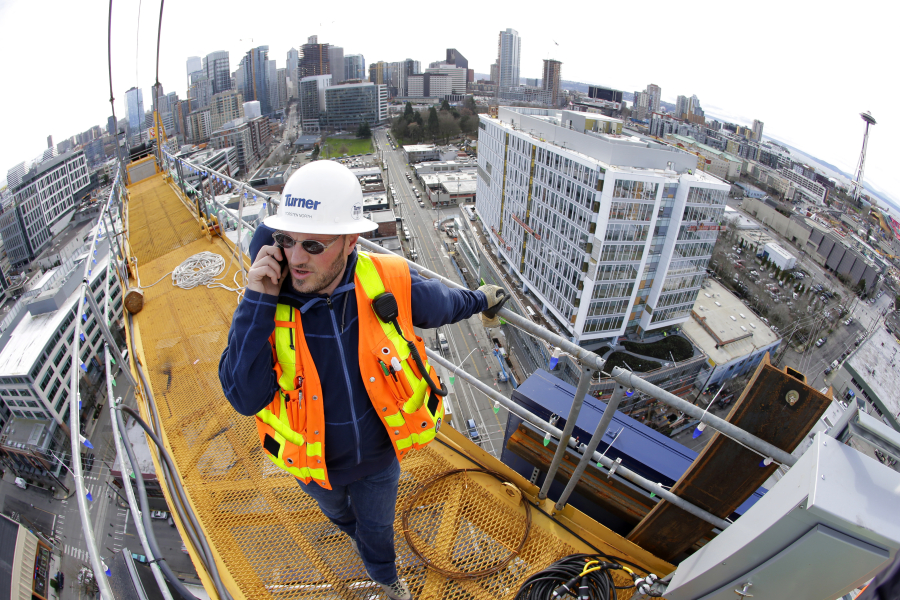 In this photo taken with a fisheye lens, Torsten North, a project foreman for Turner Construction Company, talks on his phone Feb. 10, 2015, at the top of a 238-foot-high construction crane working on a new building in Seattle&#039;s South Lake Union neighborhood. There were 58 construction cranes at work in Seattle this summer, the most of any city in the country. (Ted S.