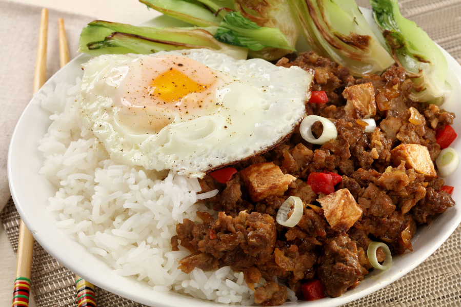 Minchi - Macanese minced meat hash - is perhaps the most accessible Fat Rice recipe for home cooks. It features ground beef and pork in a 13-ingredient marinade. The finished dish is garnished with fried egg, green onions, pickled chilies and fried potatoes.