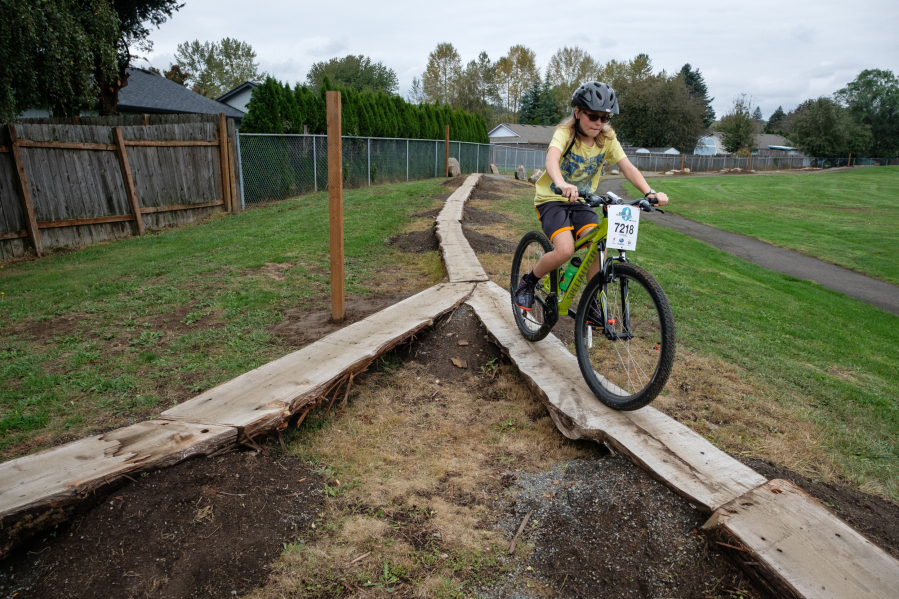Battle Ground resident Grady McHenry, 11, rides to the end of an elevated plank feature at the new Washougal Bike Park Skills Course in Hamllik Park on Saturday.