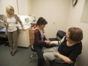 Registered nurse Gina Richardson, from left, and physical therapist Joyce Masters talk with patient Nancy Lindley of Vancouver during an appointment Sept. 7 at PeaceHealth Southwest Medical Center. Lindley, 75, was diagnosed in January with advanced lymphedema that required several weeks of compression wrapping to reduce swelling.