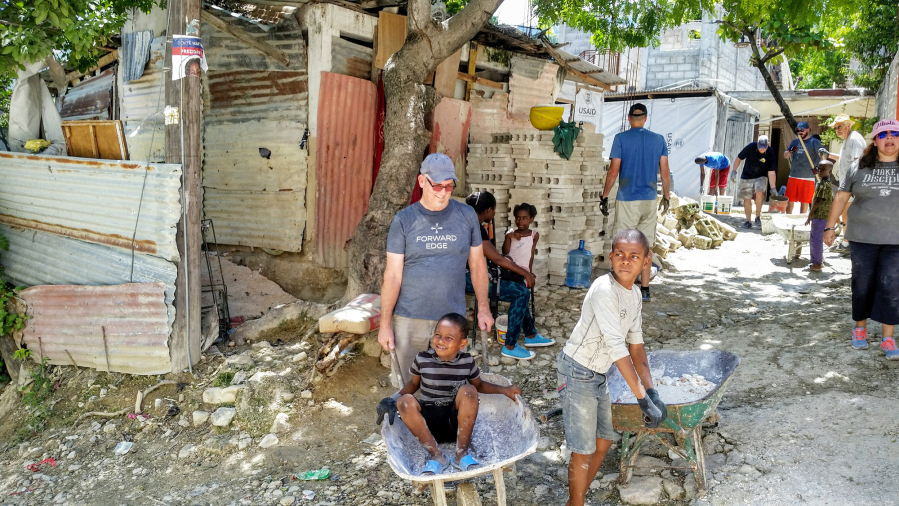 Jen Goheen meets a young Haitian during a break in the house-building project organized by Forward Edge International.