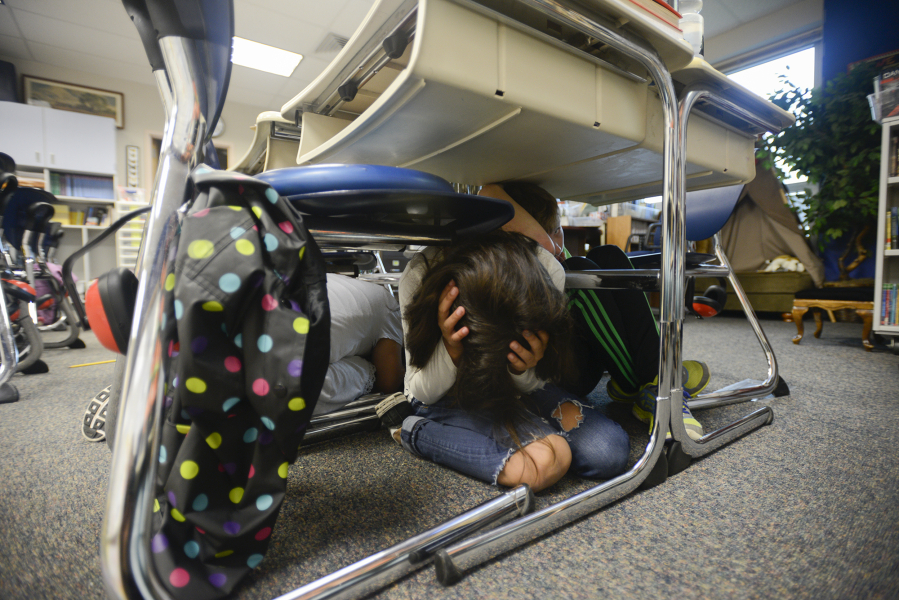 Emma Corado, a fourth-grader in Julie Menor&#039;s class at Prune Hill Elementary School, hides under her desk with classmates during an earthquake drill Thursday.