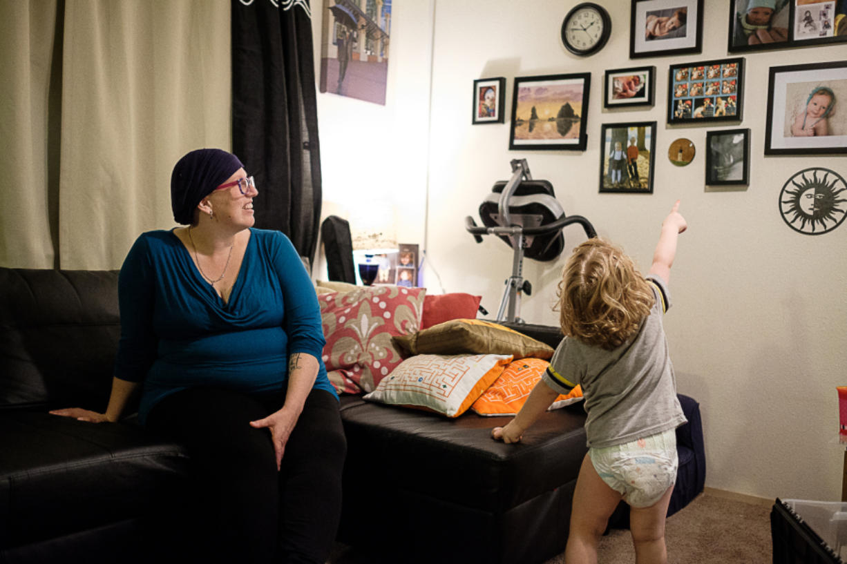 Erin Maher is juggling pregnancy, breast cancer and motherhood. Her son Liam, 2 1/2, points to family photos.