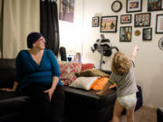 Erin Maher is juggling pregnancy, breast cancer and motherhood. Her son Liam, 2 1/2, points to family photos.