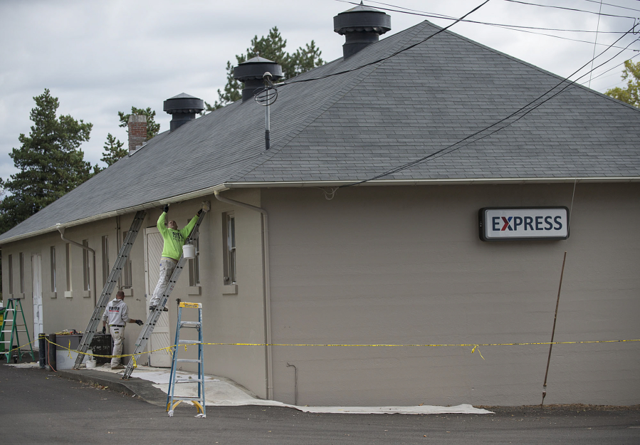 Mike Roby of Saxon Enterprises applies a fresh coat of paint Monday afternoon to the building known as a shoppette, as well as an express, at Fort Vancouver National Historic Site.