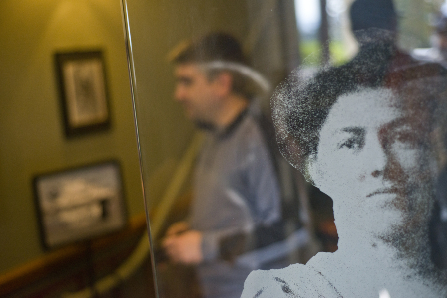 An etched-glass portrait of a woman watches guests leave the O.O. Howard House on Sunday during the Spirit Tales walking tour around Officers Row and the West Barracks.