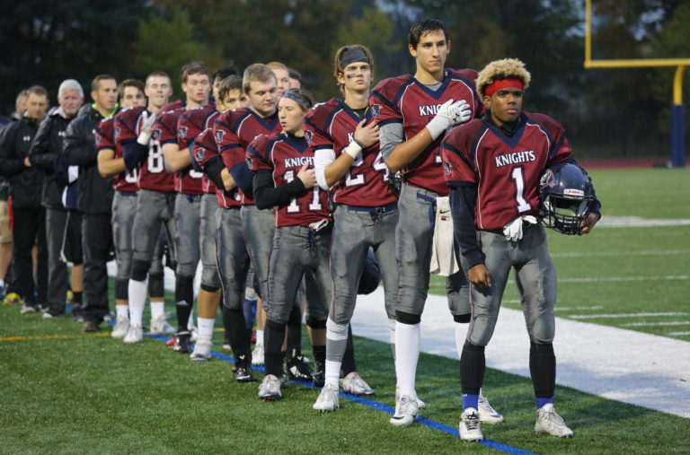 King's Way High School football players listen to the national anthem at the beginning of a game vs. Columbia High School in Vancouver Friday October 14, 2016.