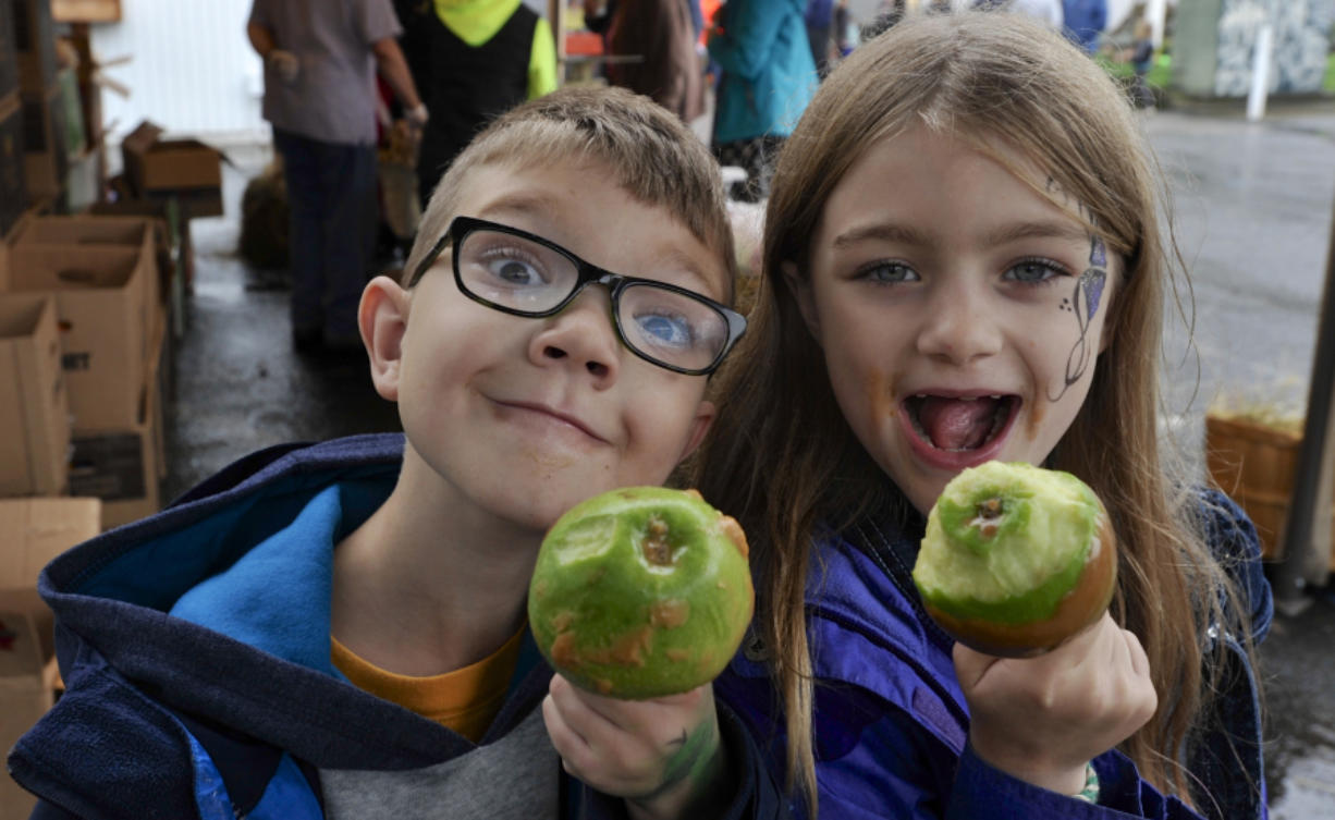 Lynnea Zevely, right, and Matthew Zevely enjoy their caramel apples at the annual apple festival Sunday at Riverside Christian School in Washougal.