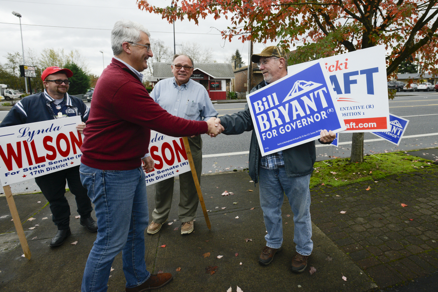 Republican gubernatorial candidate Bill Bryant, left, shakes hands with supporter Kile McCarty in Vancouver on Monday. Bryant is traveling around the state in an effort to encourage voters to be sure to cast their ballot.